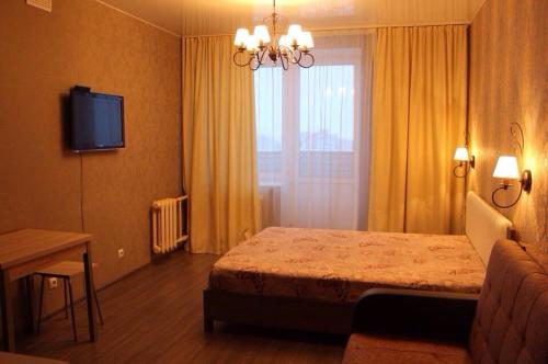 ヴォログダにあるApartments on Okruzhnoye shosse 26のベッドと窓が備わるホテルルーム