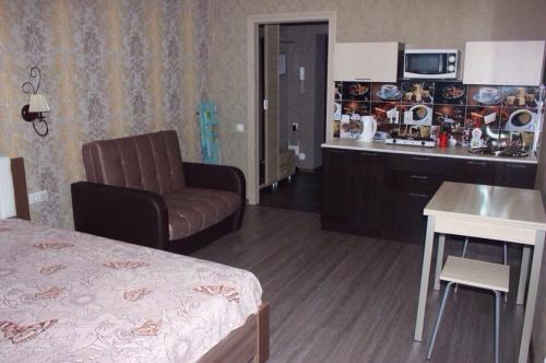 ヴォログダにあるApartments on Okruzhnoye shosse 26のベッドとキッチン付きのホテルルーム