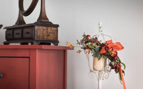 a vase with flowers on top of a red cabinet at B&B Cantico Delle Creature in Assisi