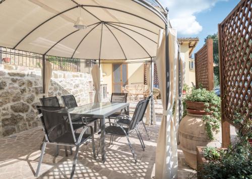 a table and chairs under an umbrella on a patio at B&B Cantico Delle Creature in Assisi