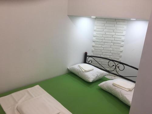a small room with two beds with green flooring at Hostel Train Station in Kyiv