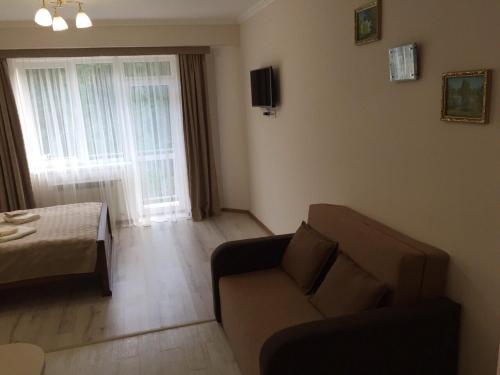 a living room with a couch and a bed at Polyana Apart in Polyana