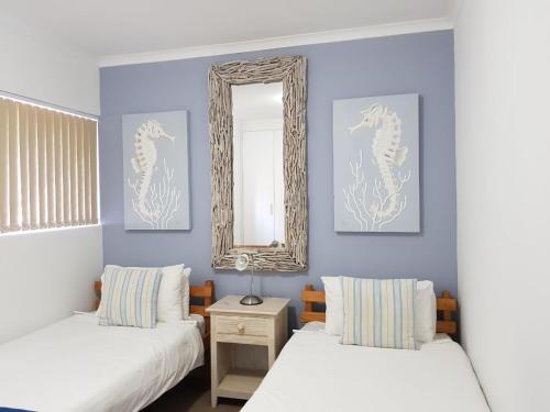 a room with two beds and a mirror on the wall at Point Village Accommodation - Santos 7 in Mossel Bay