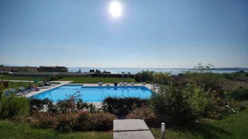 a large swimming pool with the ocean in the background at Relais Rosa Dei Venti -Ciao Vacanze- in Moniga