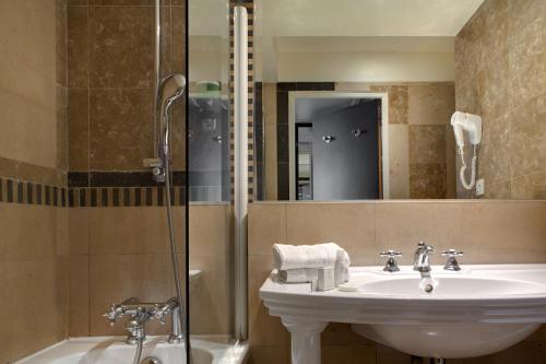a bathroom with a sink and a shower at Hotel Art Deco Euralille in Lille
