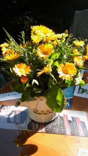 a bouquet of yellow flowers in a vase on a table at Fónagy és Walter Vendég- és Borház in Vác