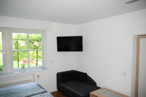 a living room with a black chair and a flat screen tv at Aaltine 3 in Bad Bentheim