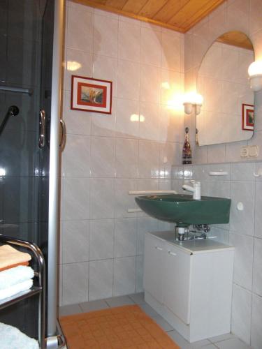 a bathroom with a green sink and a shower at Ferienwohnung Klüpfelsmühle in Schonungen