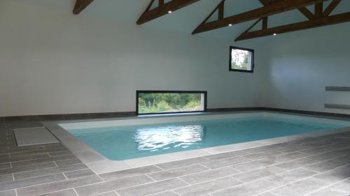 - une grande piscine dans une pièce dotée de murs et de plafonds bleus dans l'établissement Domaine de Tréouzien, à Plouhinec