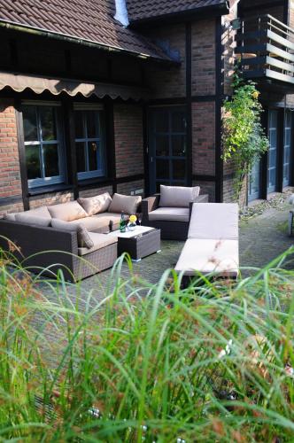 a patio with couches and a table in front of a building at Aaltine 3 in Bad Bentheim