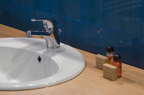 a bathroom sink with a faucet on a counter at Hotel Gio in Arad