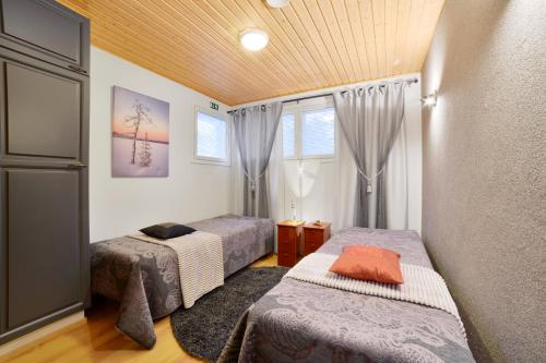 1 dormitorio con 2 camas y ventana en Vuokatin Aateli Villa Tsaari, en Vuokatti