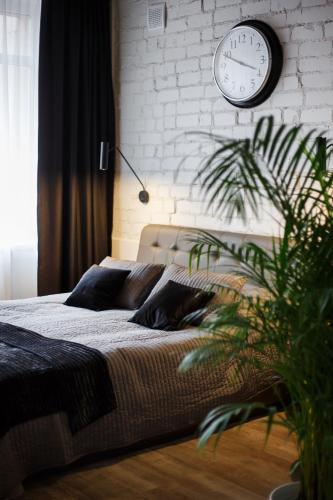 a bedroom with a bed with a clock on the wall at Old Town Trio Apartments in Vilnius