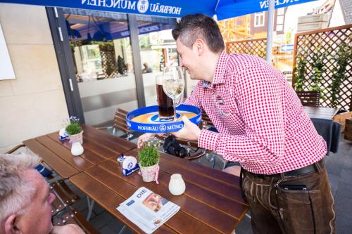 a man drinking a glass of wine at a table at Best Western Plus Hotel Ostertor in Bad Salzuflen