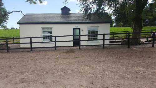 a white house with a black fence around it at The Stable Lodge Cannaway House in Macroom