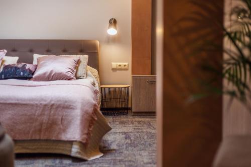 a bedroom with a bed with pink pillows at Old Town Trio Apartments in Vilnius