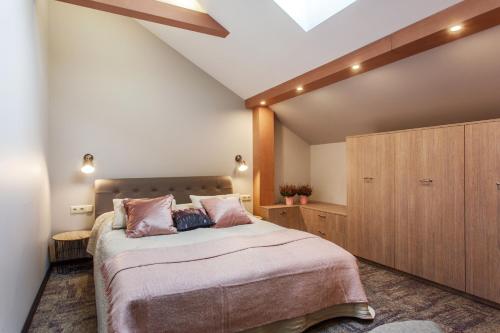a bedroom with a large bed and a wooden cabinet at Old Town Trio Apartments in Vilnius