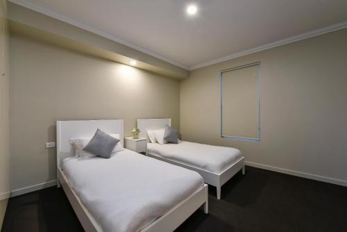 Aloha Central Luxury Apartments tesisinde bir odada yatak veya yataklar