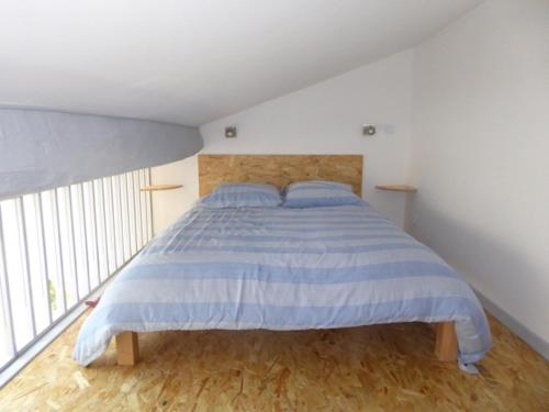 um quarto com uma cama com riscas azuis e brancas em Dans un jardin em Apremont-la-Forêt