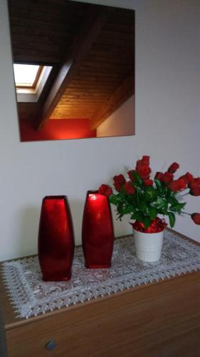 three red vases sitting on a table with a plant at Casa Delle Rose in Capaccio-Paestum
