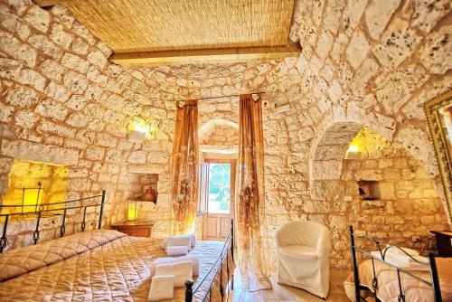 サン・ミケーレ・サレンティーノにあるTrullo Santo Stefano by PosarelliVillasの石壁のベッドルーム1室(ベッド1台付)