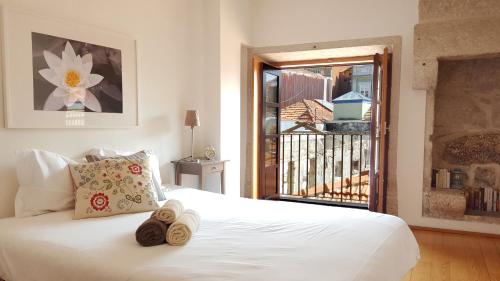 a bedroom with a white bed and a balcony at Flowerstreet 54 in Porto