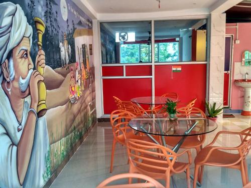 a dining room with a table and chairs and a mural at Bliss Guest House Assi Ghat in Varanasi