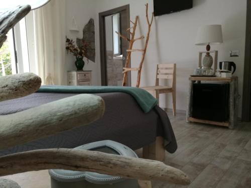 a bedroom with a bed with a green blanket at B&B Les Chambres Rooms & Suite in Santa Teresa Gallura