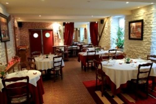 un restaurant avec des tables et des chaises avec une nappe blanche dans l'établissement Au Bon Laboureur, à Bray-sur-Seine