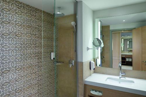 a bathroom with a shower and a sink and a mirror at TUI BLUE Palm Garden in Kizilagac