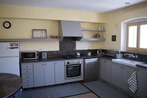 a kitchen with white cabinets and a stove top oven at Casa Le Bouganville in Sant Vicenç de Montalt