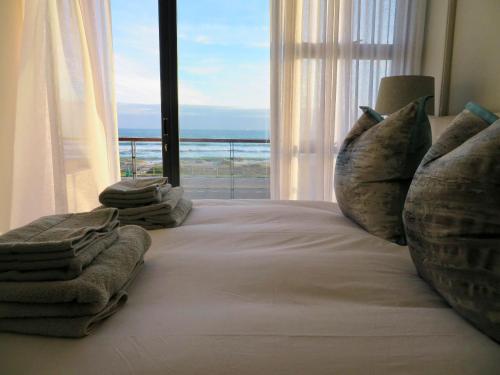 a bedroom with a bed with a view of the ocean at Blouberg Luxury Beachfront Apartment in Bloubergstrand