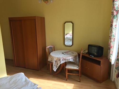 a room with a table and a mirror and a tv at Boutiquehotel Stefanie in Bad Vöslau