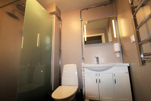 a bathroom with a toilet and a sink and a shower at Easy Livin' Apartment Hotel in Växjö