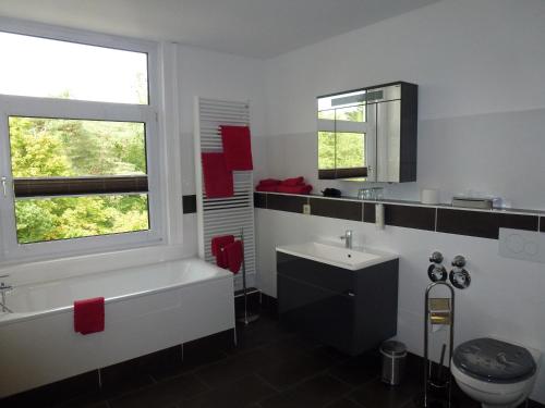 a bathroom with a tub and a sink and a toilet at Hotel Wildunger Hof mit Gemeinschaftsküche in Bad Wildungen