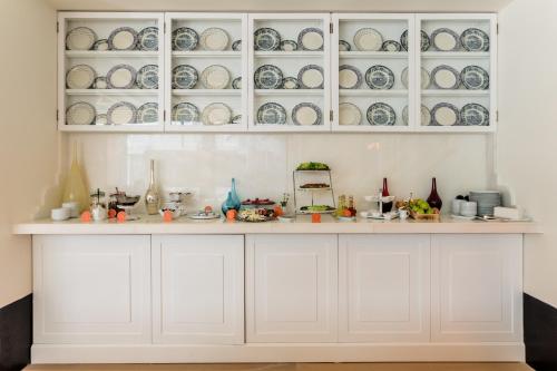 a kitchen with white cabinets with plates and dishes at Room Mate Emir, Istanbul in Istanbul