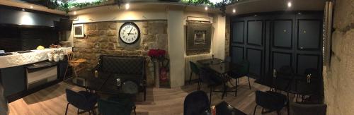 a room with chairs and a clock on a stone wall at Hôtel Etoile Trocadéro in Paris