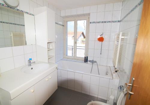 a bathroom with a tub and a sink and a toilet at City Center Holiday Apartment in Interlaken
