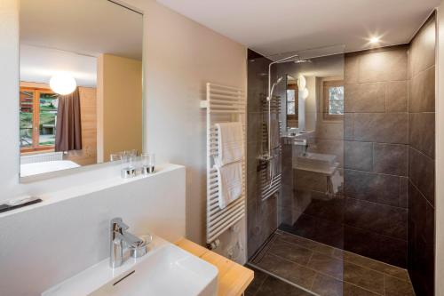 a bathroom with a sink and a shower at Hotel Breithorn in Blatten im Lötschental