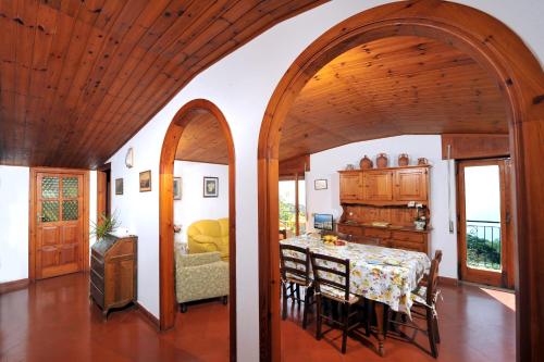 una sala da pranzo con tavolo e sedie e una cucina di Villa Persico a Massa Lubrense
