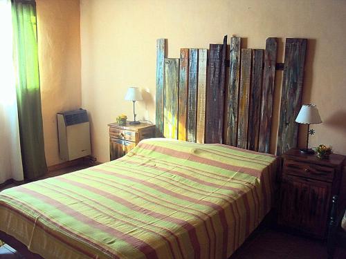 1 dormitorio con 1 cama con edredón a rayas en Pasos Cortos Cabañas Nono en Nono
