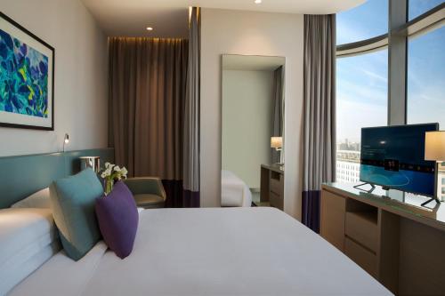 a hotel room with a bed and a television at Capital Centre Arjaan by Rotana in Abu Dhabi