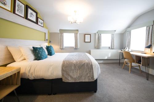 a hotel room with a large bed and a desk at The Hedgehog by Innkeeper's Collection in Lichfield