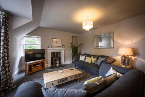 a living room with a couch and a tv at The Apartment in Portree