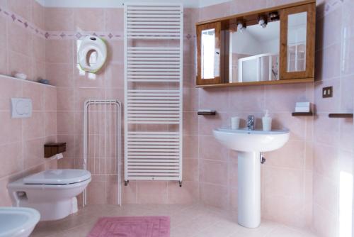 a bathroom with a sink and a toilet and a mirror at Villa Serena in Aosta