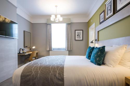 a bedroom with a large bed with blue pillows at The Hedgehog by Innkeeper's Collection in Lichfield