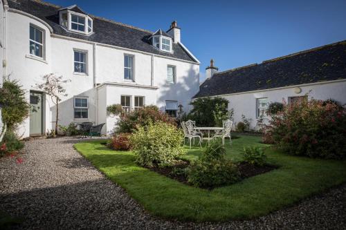 a garden in front of a white house at Dalzie in Portree