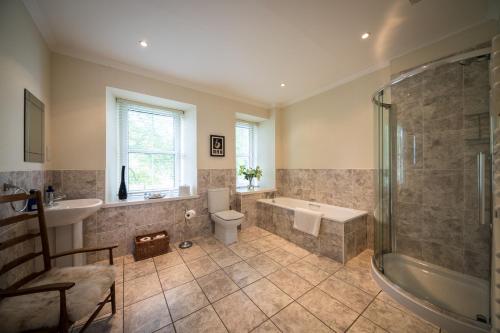 a bathroom with a tub and a toilet and a sink at Dalzie in Portree