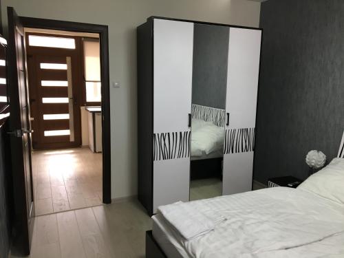 a bedroom with a large mirror and a bed at Kristály apartmanok in Kisvárda