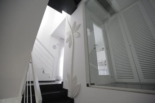 a hallway with a staircase and a mirror on the wall at Piccola Caracas B&B in Licata